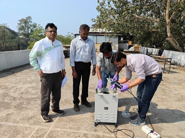 A group of men standing outside with a microscope

AI-generated content may be incorrect.