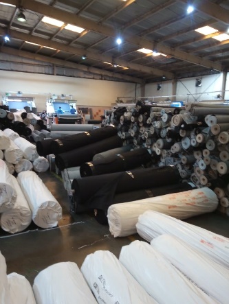 Rolls of fabric in a warehouse

AI-generated content may be incorrect.